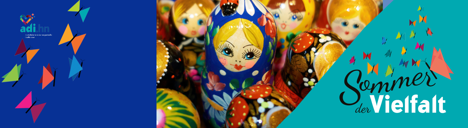 Links sind Schmetterlinge und das Logo der adi eingeblendet. In der Mitte sieht 7 russische Puppen in verschiedenen Größen, die eng nebeneinander stehen. In der Mitte ist eine größere Puppe mit blauem Kopftuch und gelben Haaren. Sie schaut aus dem Bild heraus. Die Gruppe ist von schräg oben fotografiert. Rechts ist das Logo vom Sommer der Vielfalt